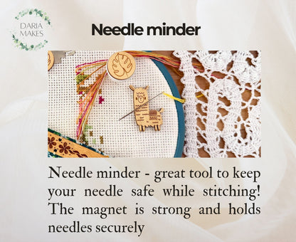 Needle minder with cross-stitching and lace background, featuring the brand 'Daria Makes'.